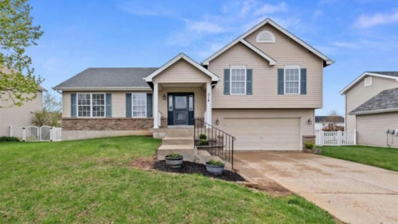 A tan two-story home with black shutters in the Villages of Stonegate