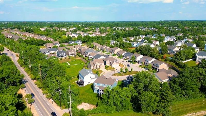 Aerial view of a Wildwood neighborhood of homes set among mature trees