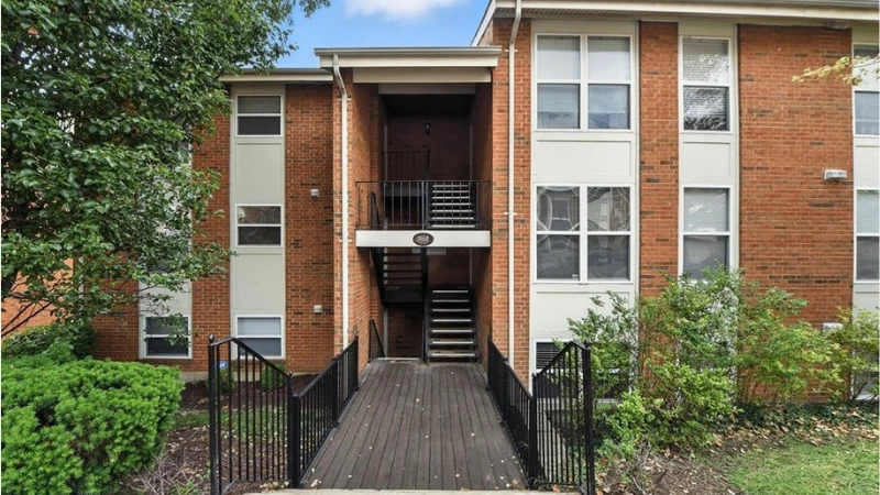 A 1980s condo building of tan siding and brick with balconies, in downtown Kirkwood