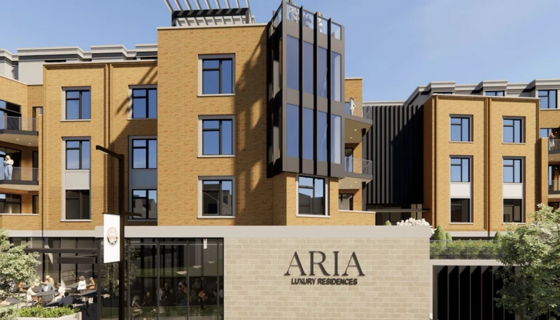 Aria Luxury Residences, a modern condo building in tan brick and dark metal, with its name over the entrance