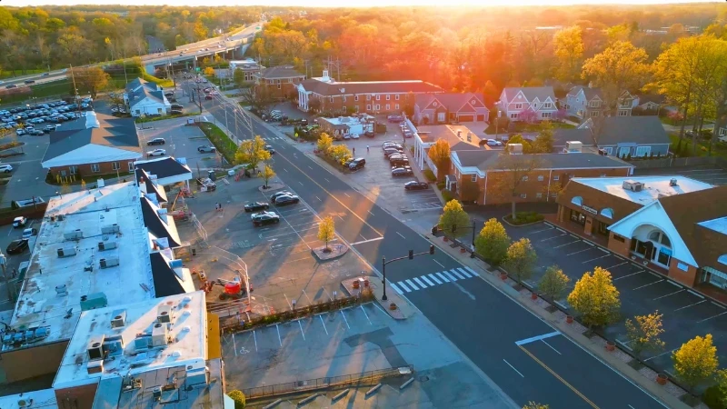 Aerial view of the Shoppes at Ladue retail buildings and parking along Clayton Road at sunset