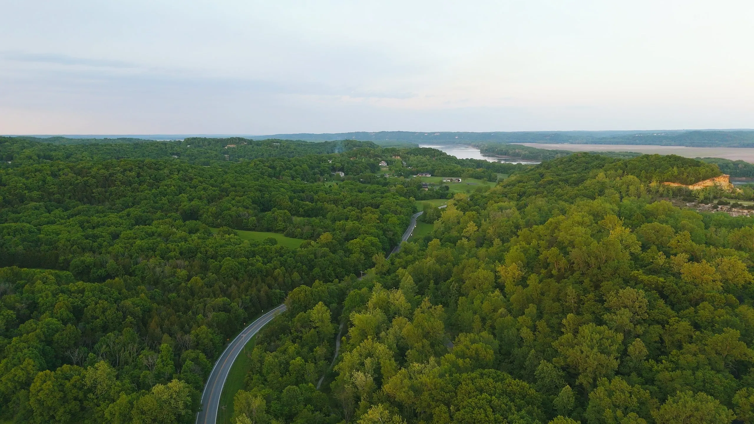 Aerial view of Route 94 winding through the wooded hills near Augusta, Missouri, with the Missouri River in the distance