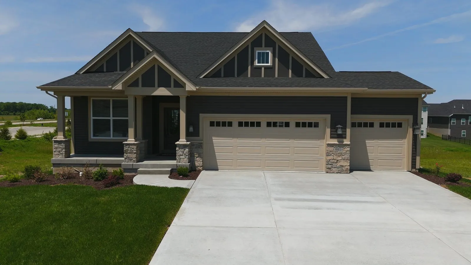 A single level ranch home at Cottleville Trails with a wide front elevation, stone accents and a three car garage