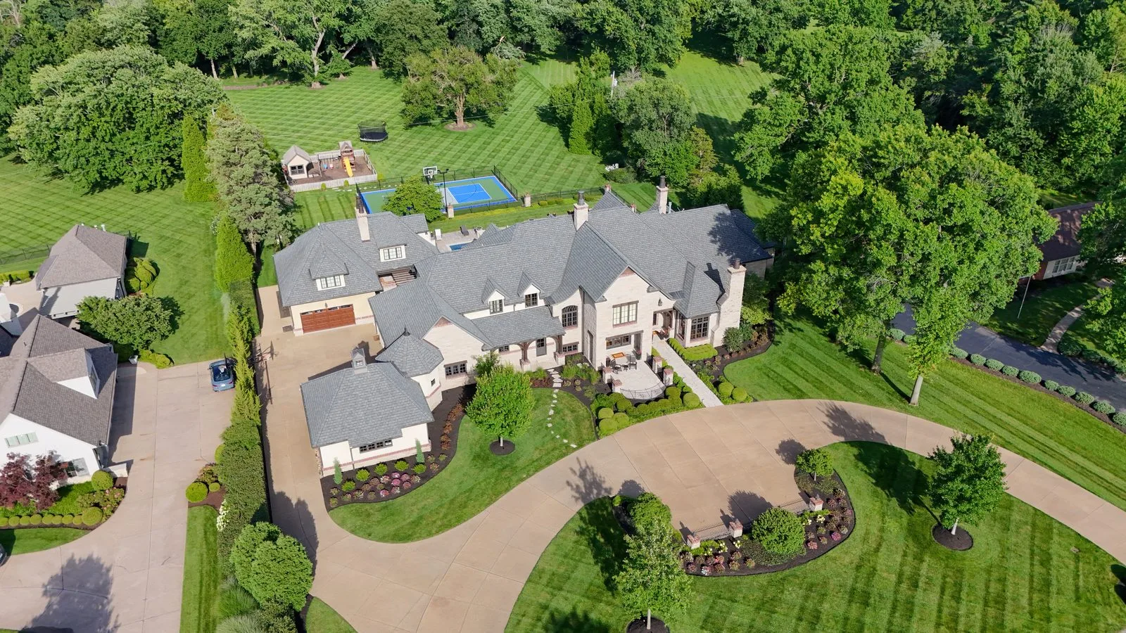 Aerial view of a mansion on Bridle Lane in Frontenac, Missouri, set back behind mature trees on a large wooded lot