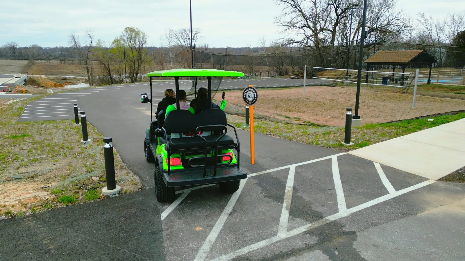A green golf cart pulling into the marked golf-cart parking lot behind Frankie Martin's Garden in Old Town Cottleville