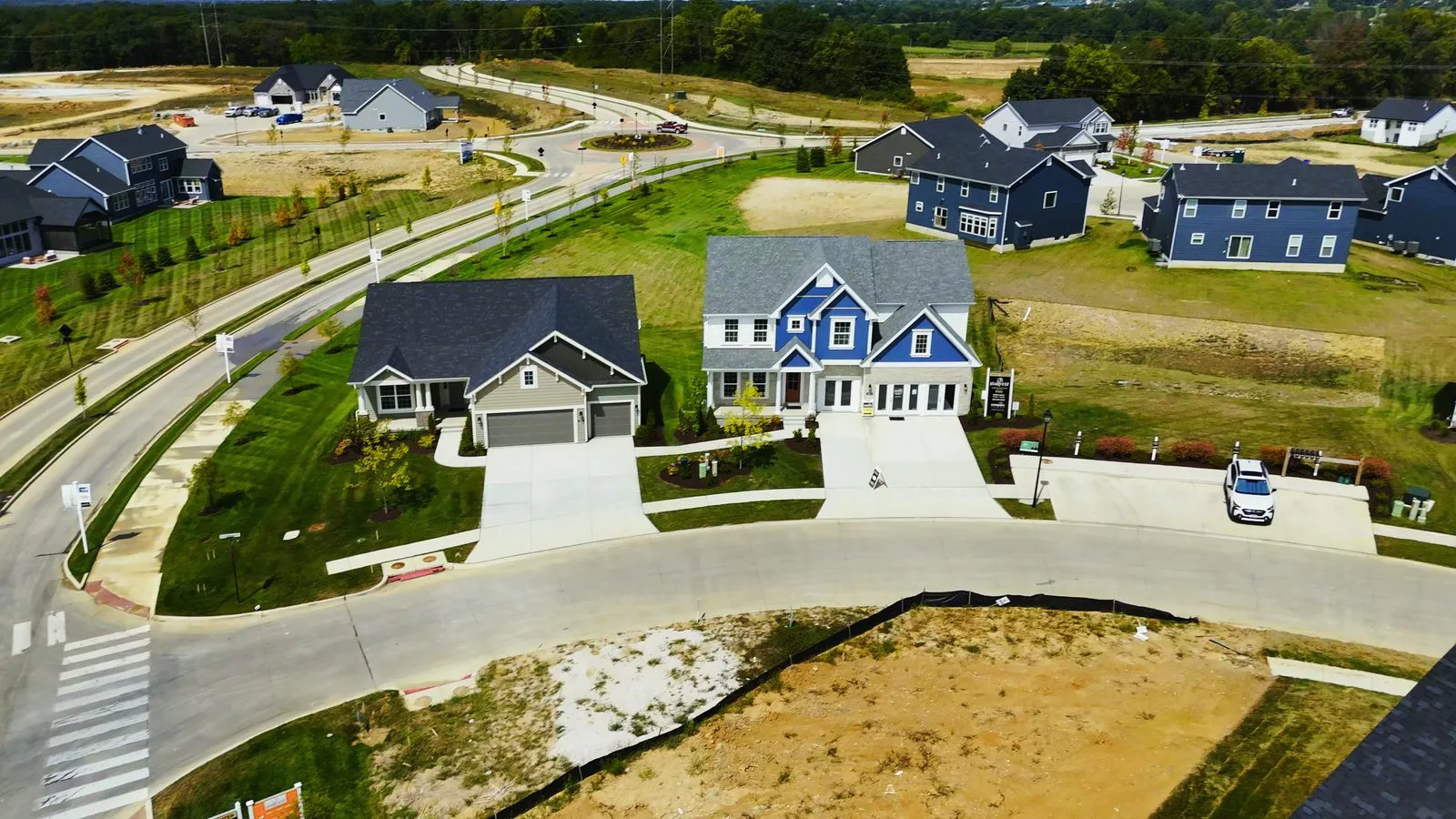 Completed single family homes built by Consort Homes at Harvest in August 2025, larger two-story houses with landscaped front lawns