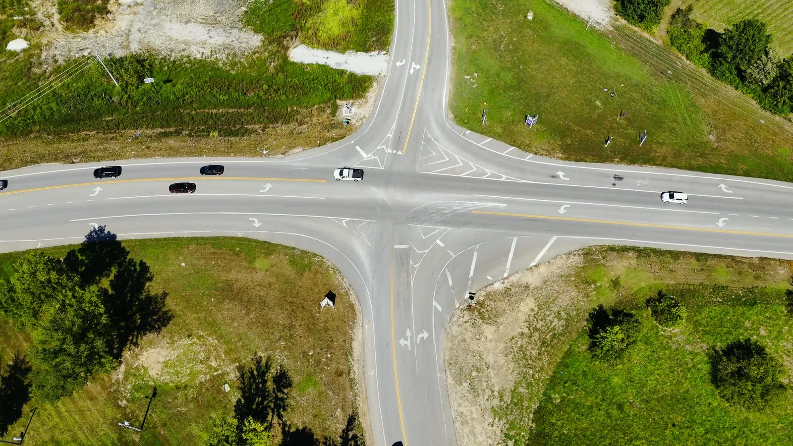 Aerial photograph of the Duello Road and Hopewell Road intersection beside Harvest in August 2025, showing the two-lane roads, new turn lanes under construction and the surrounding farmland being developed