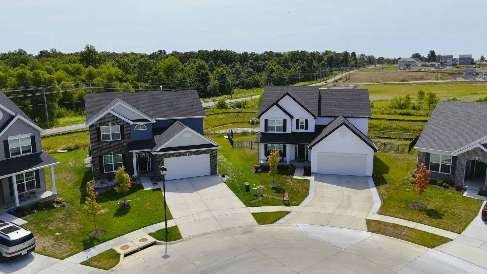Aerial photograph of a completed McBride cul-de-sac at Harvest in August 2025, a ring of finished homes with landscaped lawns