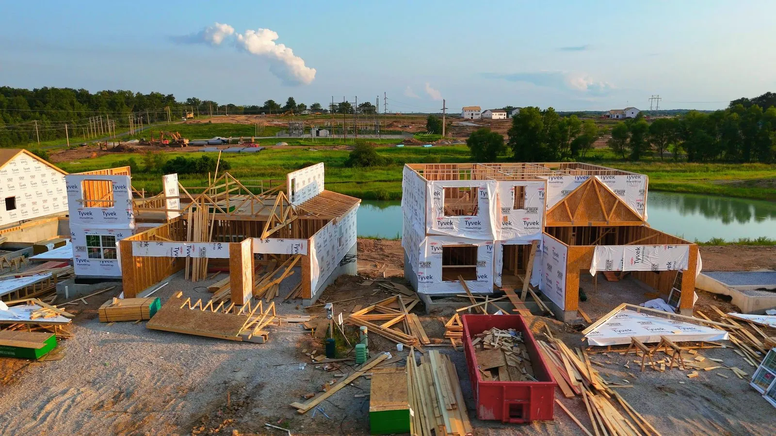 Aerial photograph of Harvest in July 2024 with McBride homes in framing along a new street and bare graded ground stretching away behind them