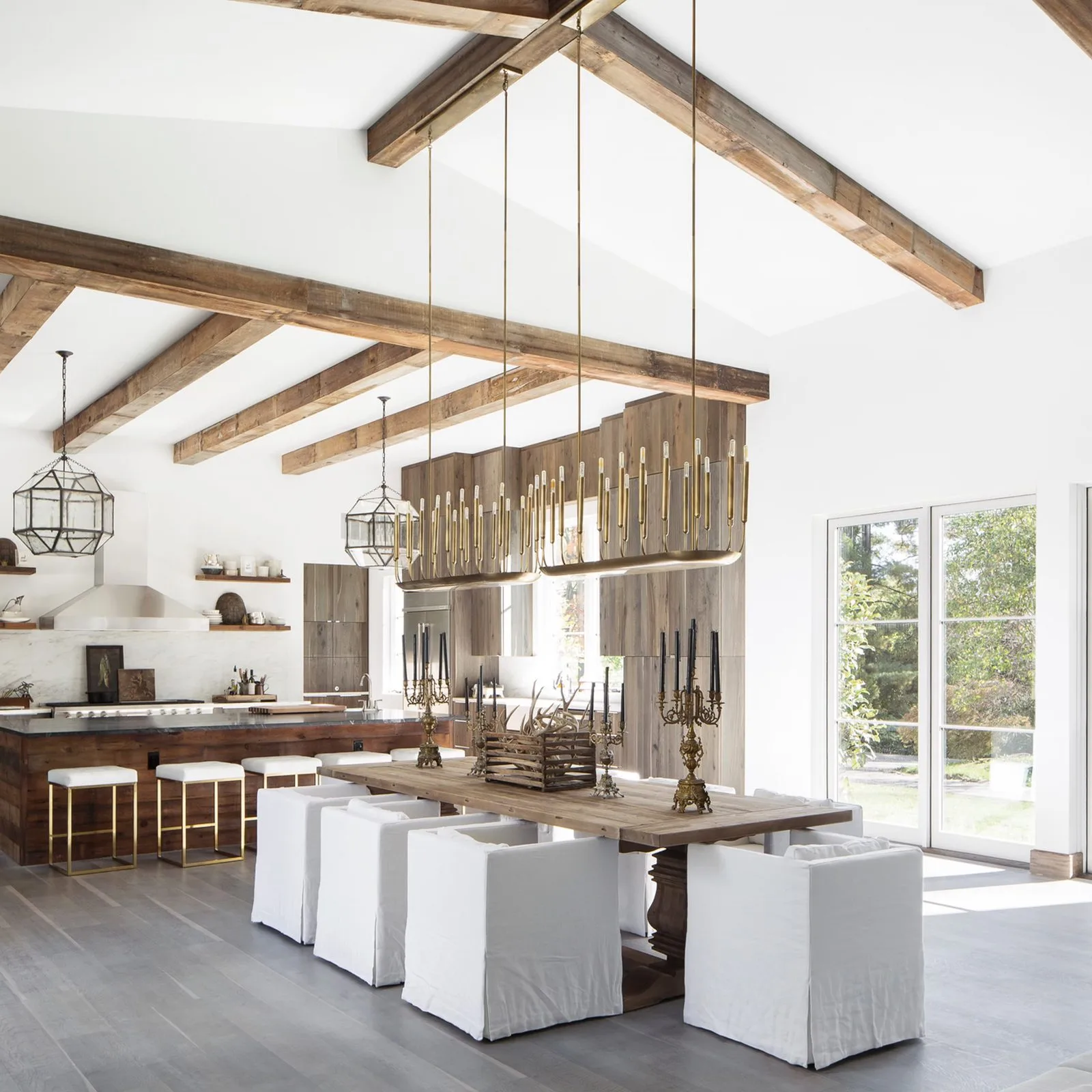 Rustic modern kitchen and dining room with reclaimed wood ceiling beams inside 28 Somerset Downs in Ladue, Missouri