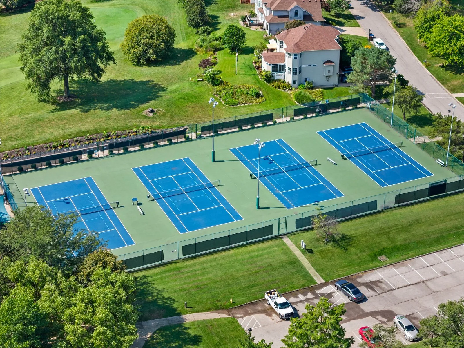 Aerial view of the four Lake St. Louis Community Association tennis courts surrounded by lawn and homes