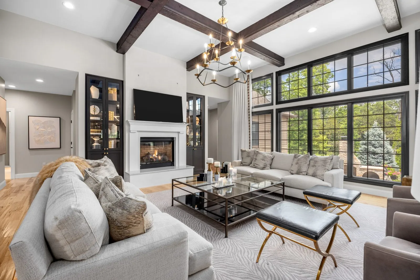 Great room with a vaulted beamed ceiling, fireplace and floor to ceiling windows