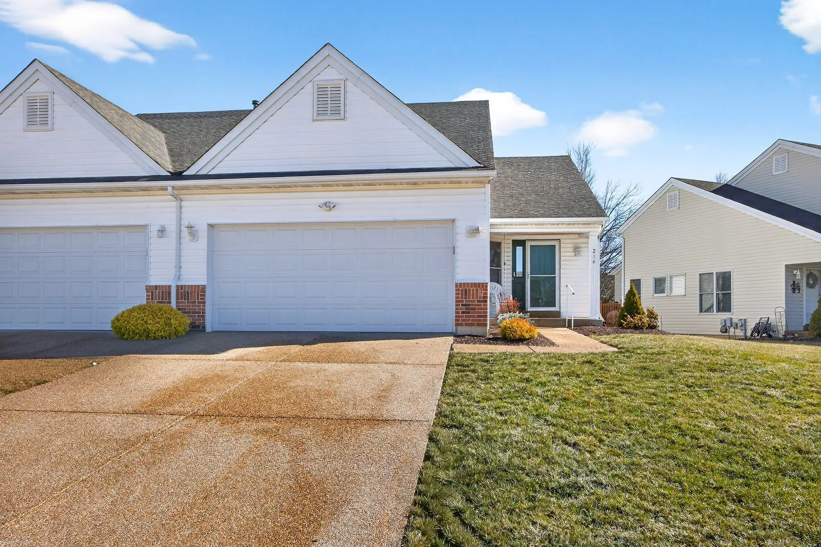 Professionally photographed villa exterior with a two car garage and front walk