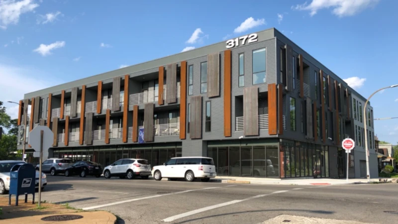 A modern three-storey mixed-use building in brick and metal on Morgan Ford Road