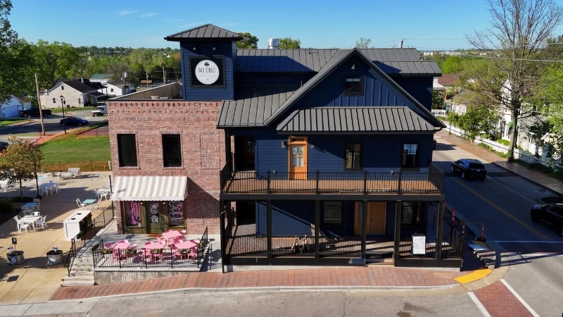 Aerial view of the Oak Street Inn & Lounge, a three-story brick building with balconies, on Oak Street in Old Town Cottleville