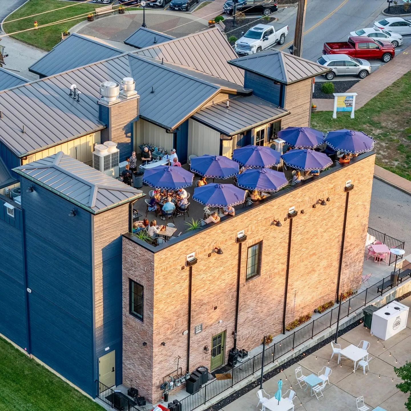 Aerial view of the Oak Street Inn rooftop patio in Cottleville, with navy umbrellas over the tables