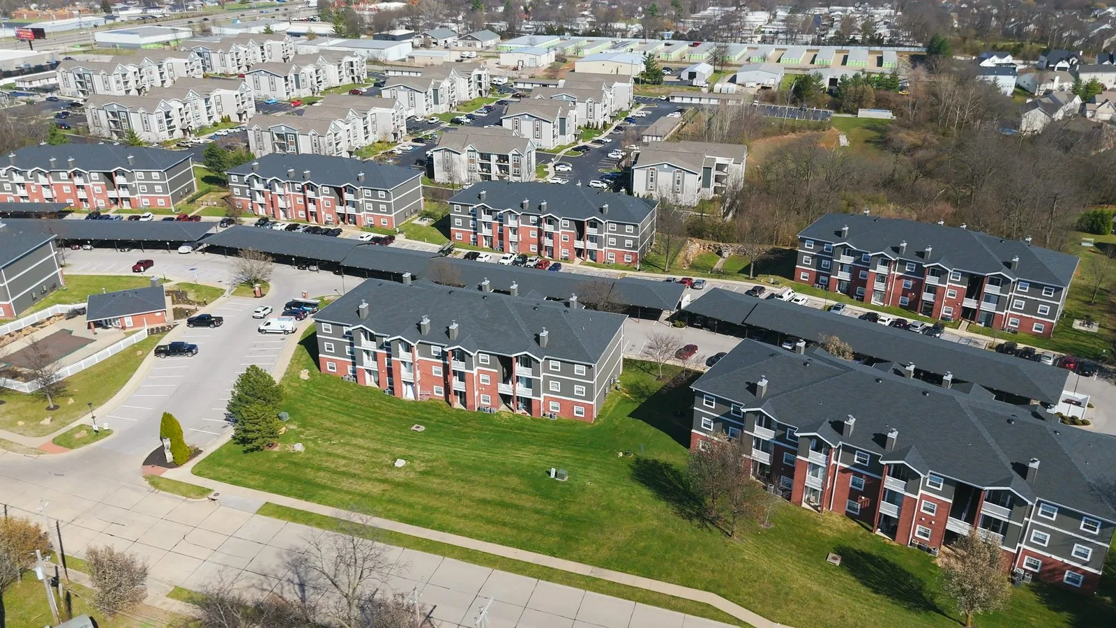 Aerial view of a multi-building apartment community with surface parking in O'Fallon, MO
