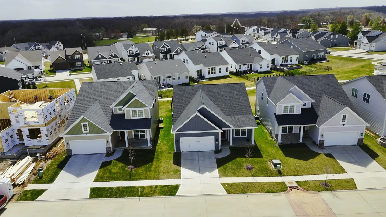 New McKelvey homes in Sommerlin, O'Fallon, MO, with one house still being framed, March 2025
