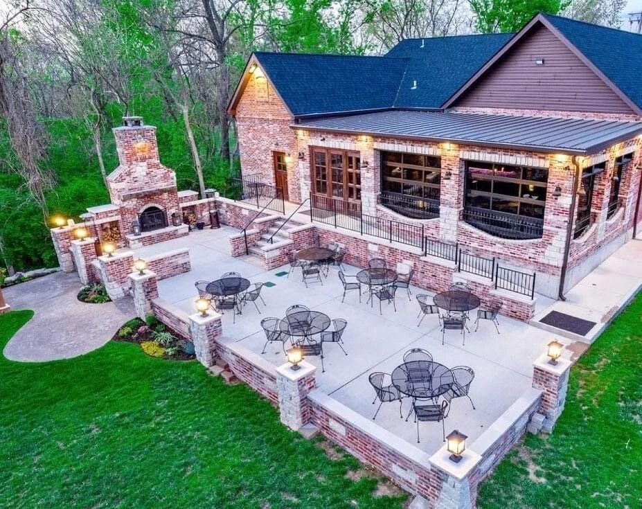 Aerial view of Public School House in Cottleville, a brick venue with a patio, outdoor fireplace and lawn