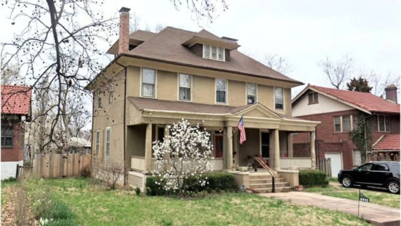 The same house today, in color, with mature planting and neighboring homes around it