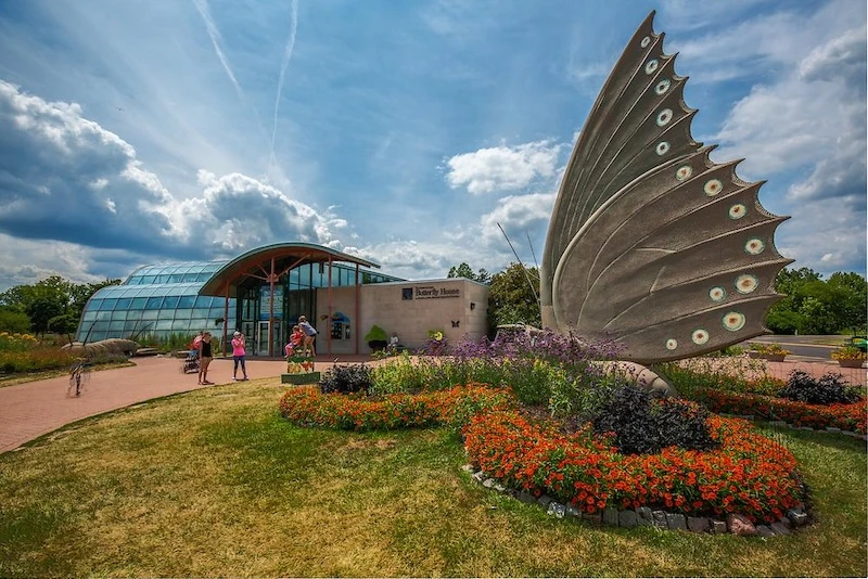 The Sophia M. Sachs Butterfly House at Faust Park, with its butterfly wing sculpture and flower beds