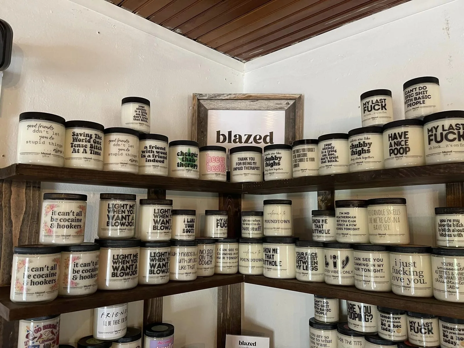Shelves of scented candles with printed labels inside The Craft Cottage in Cottleville