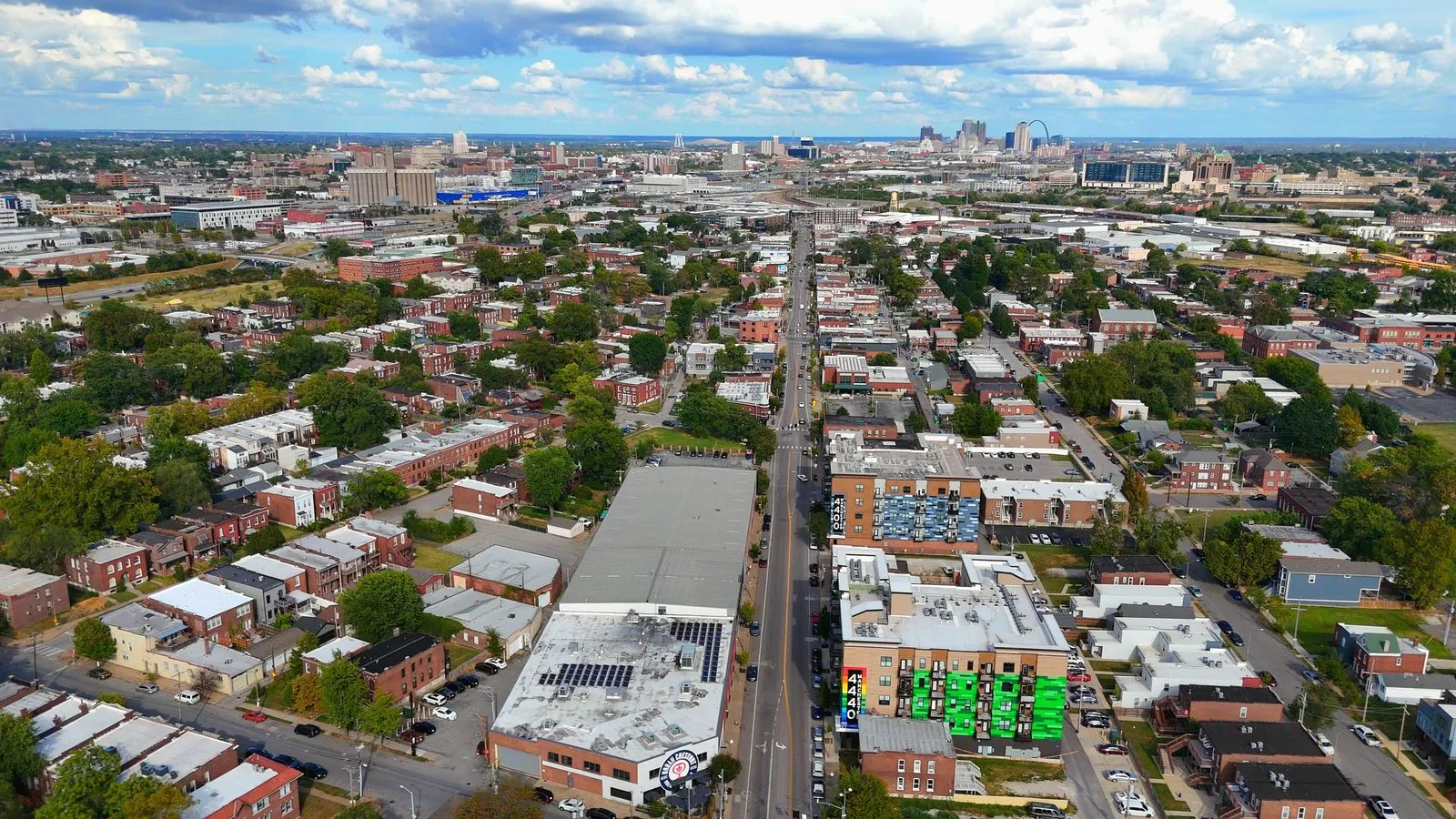 Aerial view looking east along Manchester Avenue through The Grove in St. Louis, with downtown and the Gateway Arch on the horizon