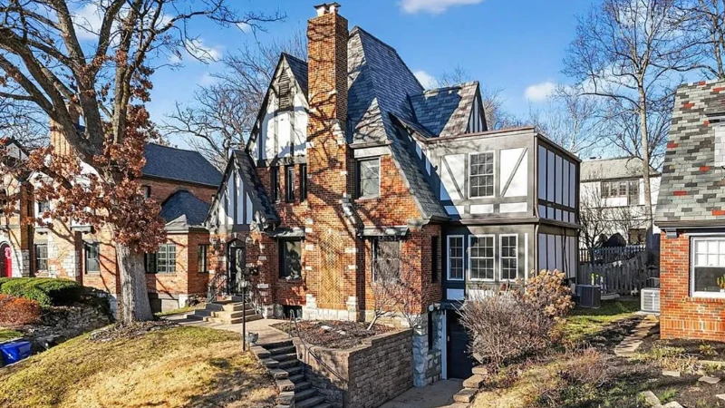 A Tudor-style brick and stucco home with a steep gabled roof, near Delmar Boulevard