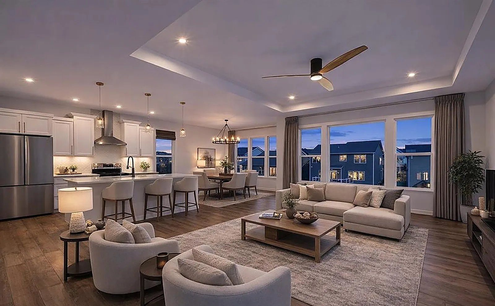 Virtually staged great room with sofas, chairs and a rug, shown at dusk