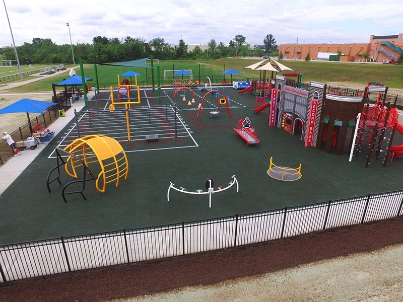 Aerial view of Jake's Field of Dreams, the fenced all-abilities playground in Wentzville with its rubber surface, ramps, and shade sails
