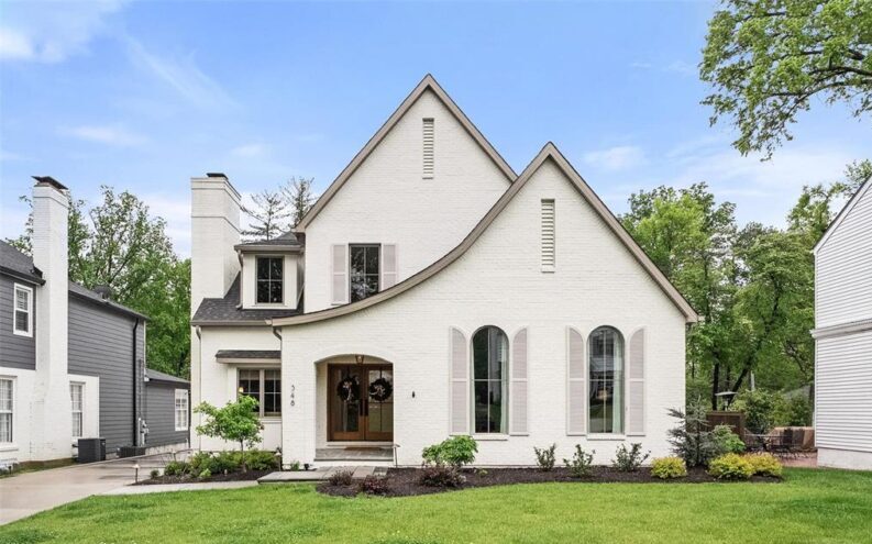 white brick home with green lawn